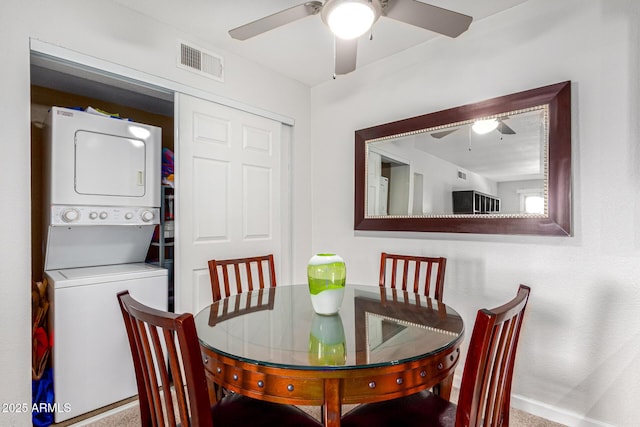 dining room featuring ceiling fan and stacked washer and clothes dryer