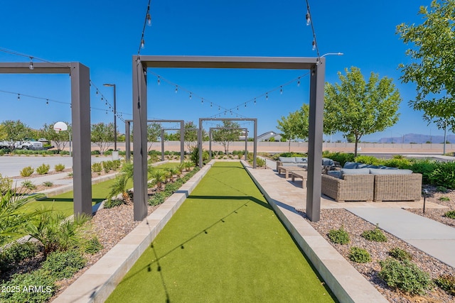 view of home's community with outdoor lounge area and a bocce ball area