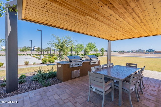 view of patio with a grill, an outdoor kitchen, and outdoor dining space