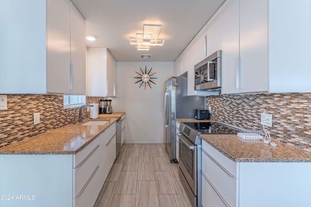 kitchen featuring a sink, tasteful backsplash, appliances with stainless steel finishes, visible vents, and white cabinets