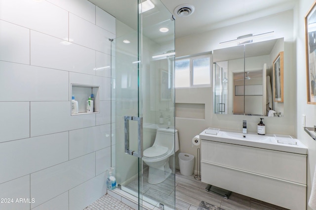 bathroom featuring a shower stall, visible vents, toilet, and vanity