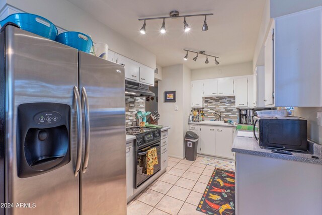 kitchen with light tile patterned flooring, white cabinetry, black appliances, and under cabinet range hood