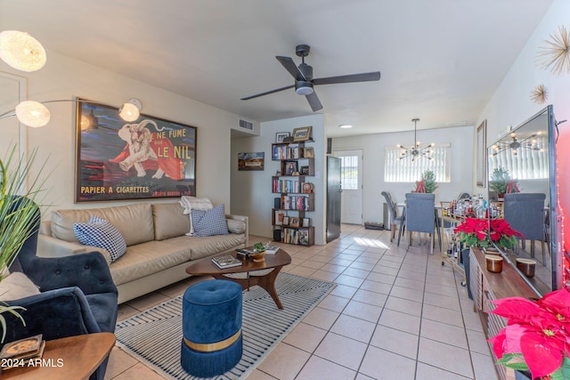 living area featuring ceiling fan with notable chandelier, visible vents, and light tile patterned floors