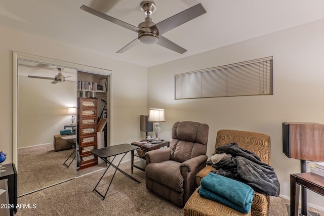 living area featuring carpet flooring, baseboards, and ceiling fan