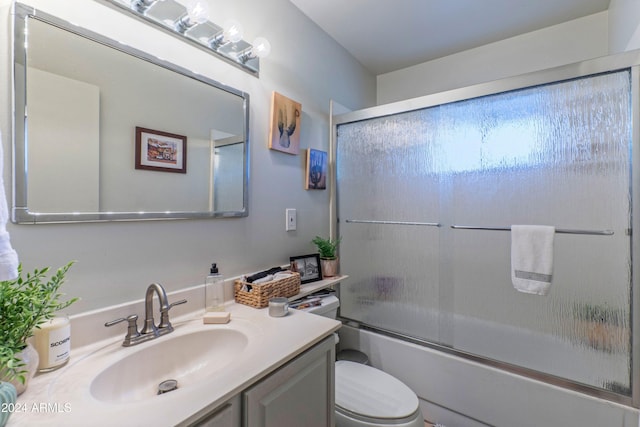 full bathroom with toilet, vanity, and combined bath / shower with glass door