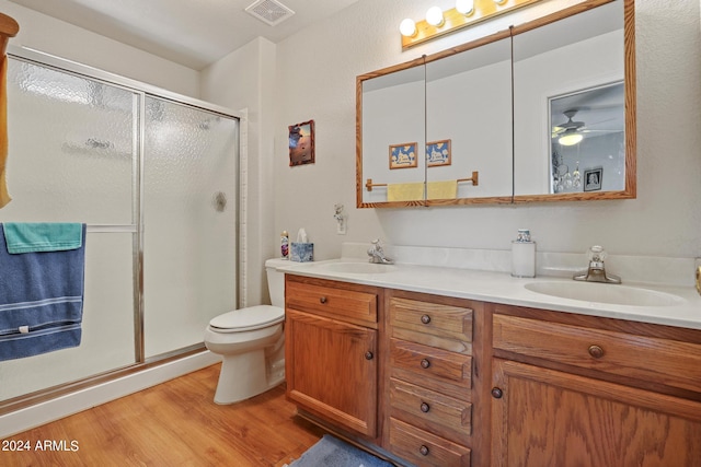 bathroom with ceiling fan, toilet, an enclosed shower, vanity, and hardwood / wood-style flooring