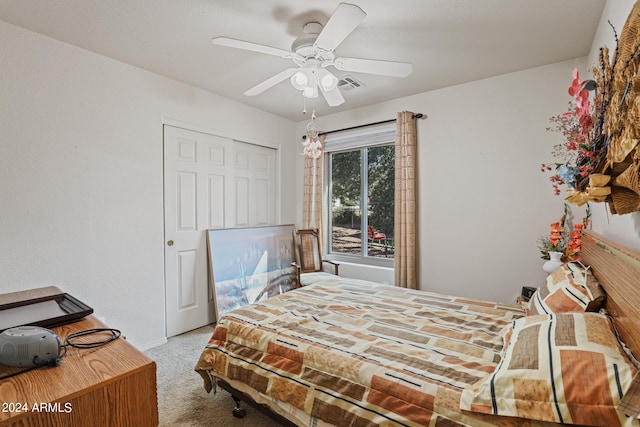 carpeted bedroom featuring ceiling fan and a closet