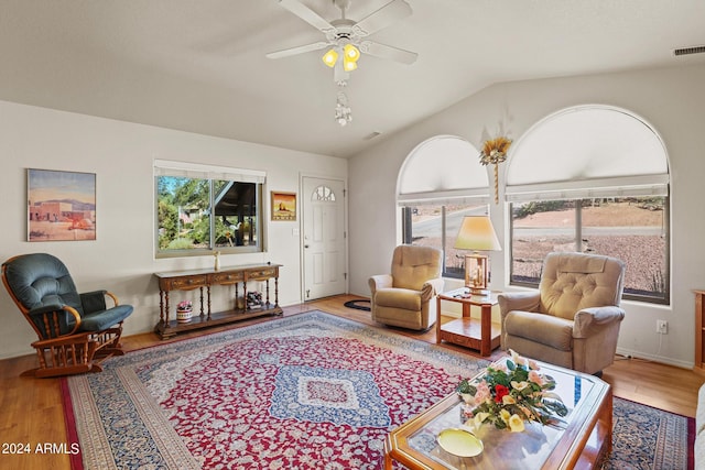 living room featuring ceiling fan, lofted ceiling, and light wood-type flooring