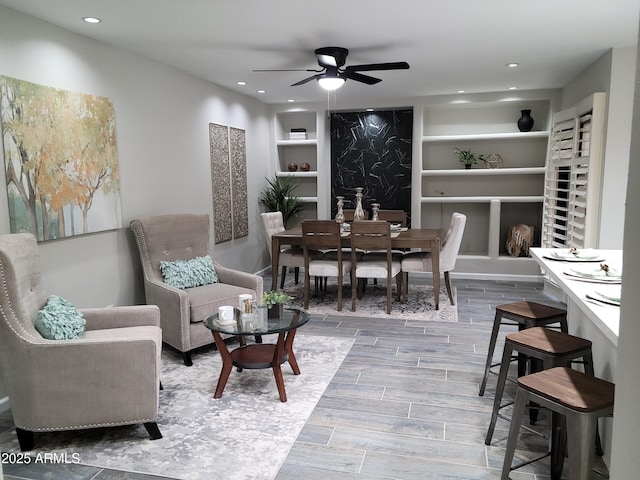 living room featuring built in shelves and ceiling fan