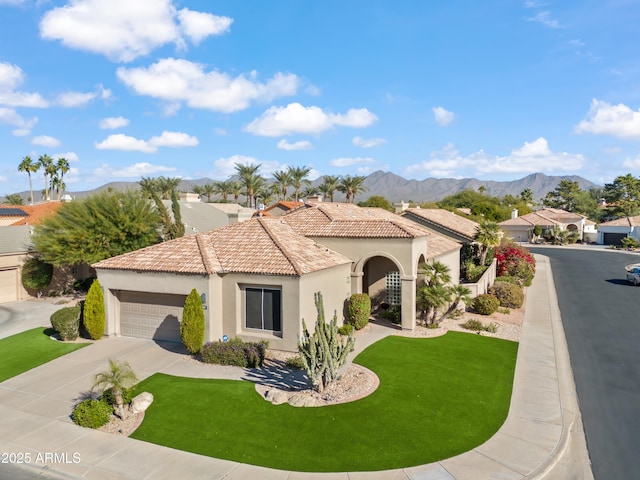 mediterranean / spanish-style house featuring a mountain view, a front lawn, and a garage