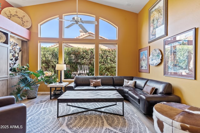 living room featuring light wood-type flooring, ceiling fan, and lofted ceiling