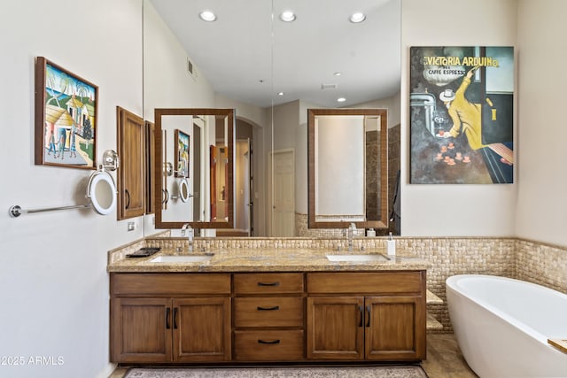 bathroom with a tub and vanity