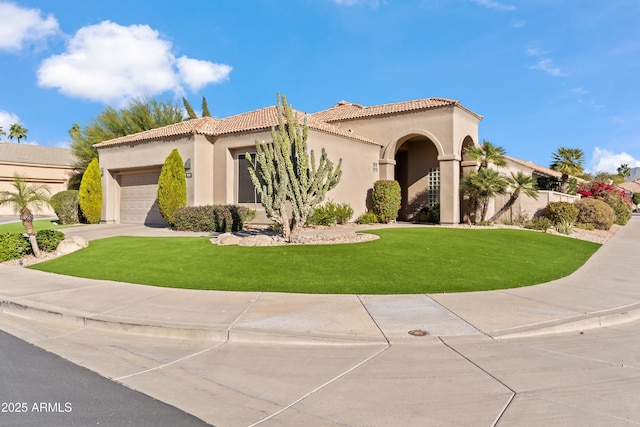 mediterranean / spanish-style house featuring a front yard and a garage