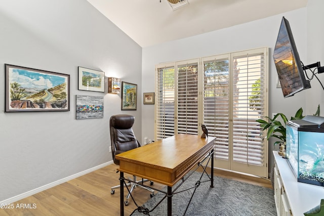 home office with light hardwood / wood-style floors and vaulted ceiling