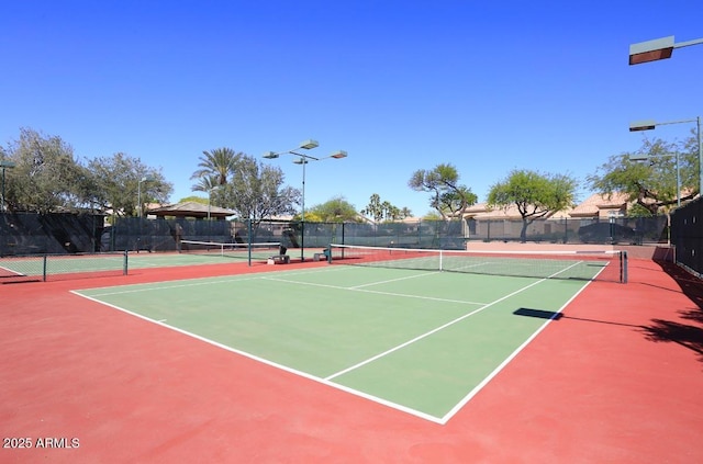 view of tennis court with basketball hoop