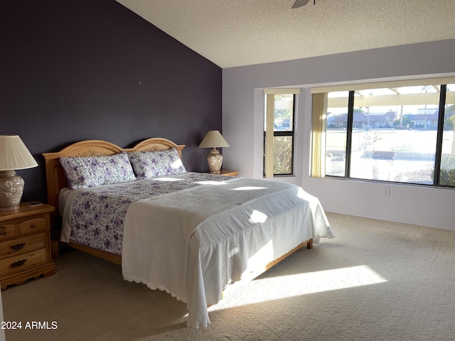 bedroom featuring carpet flooring, a textured ceiling, and vaulted ceiling