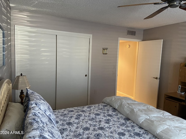 bedroom featuring ceiling fan, a closet, and a textured ceiling