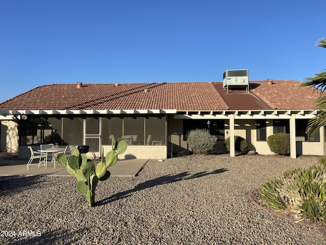 view of property exterior featuring central AC, a patio area, and a sunroom