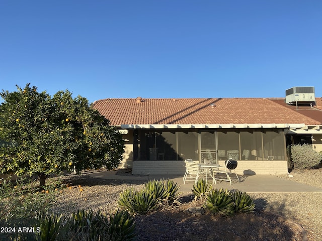 view of home's exterior featuring a sunroom, a patio, and central AC unit