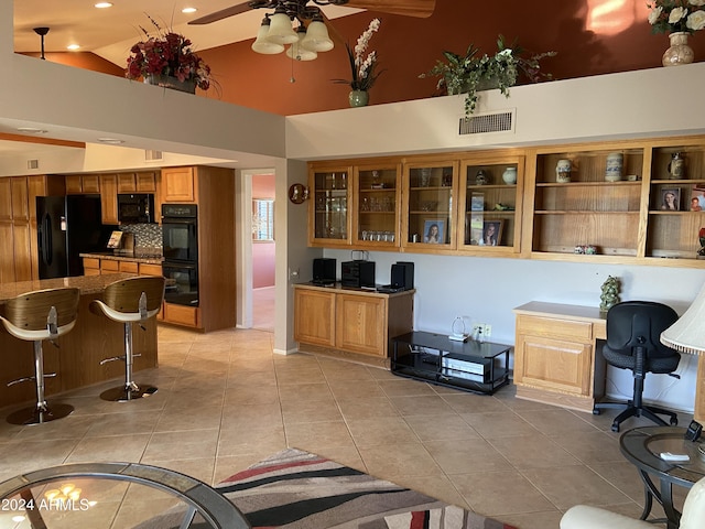 interior space featuring built in desk, high vaulted ceiling, and ceiling fan