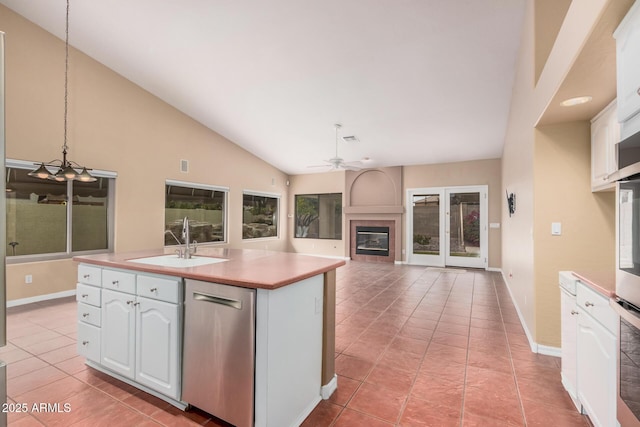 kitchen featuring sink, dishwasher, white cabinetry, hanging light fixtures, and a center island with sink