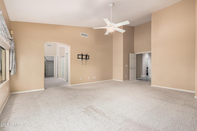 carpeted empty room featuring high vaulted ceiling and ceiling fan