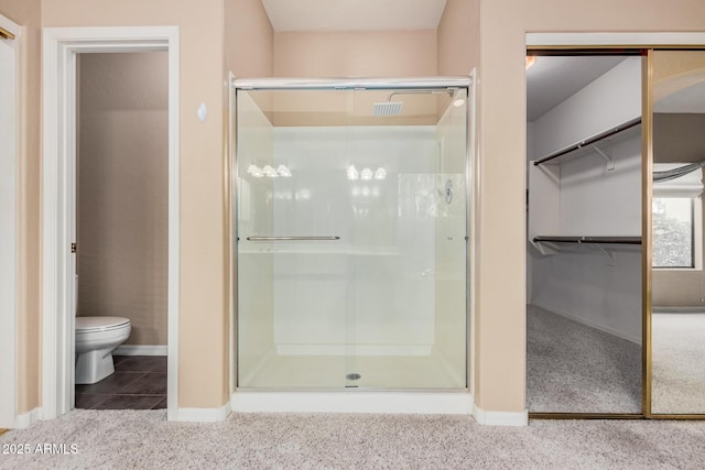 bathroom featuring walk in shower, toilet, and tile patterned flooring