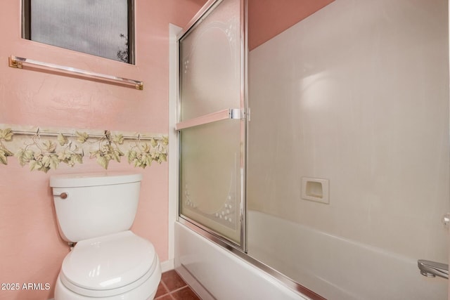 bathroom featuring shower / bath combination with glass door and toilet