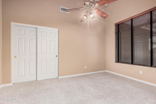 unfurnished bedroom with ceiling fan, a closet, and light carpet