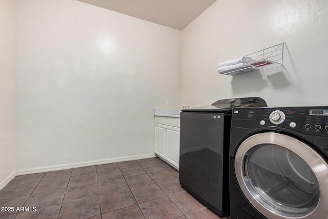 laundry area with cabinets, washing machine and clothes dryer, and tile patterned floors