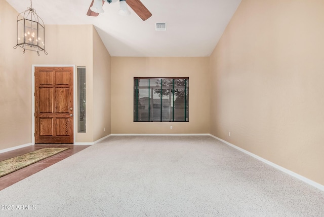 empty room featuring lofted ceiling, carpet floors, and ceiling fan with notable chandelier