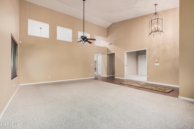 interior space featuring a towering ceiling and ceiling fan with notable chandelier