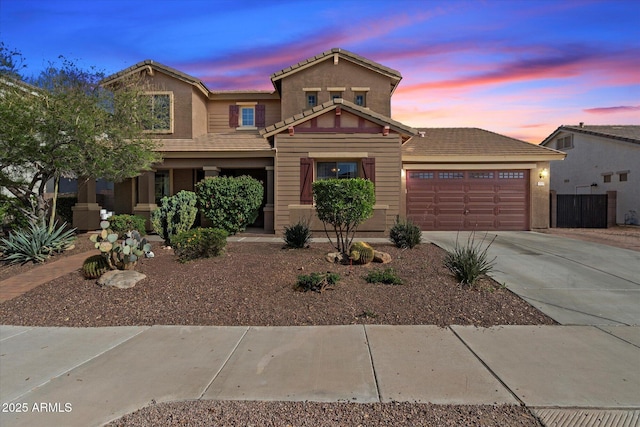view of front of home with a tile roof, stucco siding, a garage, and concrete driveway