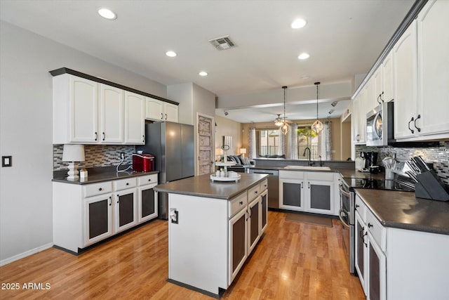 kitchen featuring tasteful backsplash, visible vents, appliances with stainless steel finishes, and dark countertops