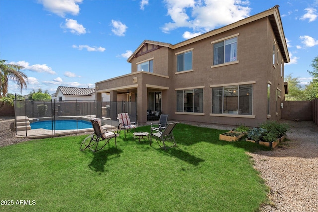 back of property featuring a fenced in pool, a ceiling fan, a fenced backyard, a lawn, and a vegetable garden