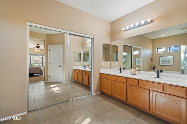 bathroom featuring double vanity, tile patterned flooring, ensuite bathroom, ceiling fan, and a sink