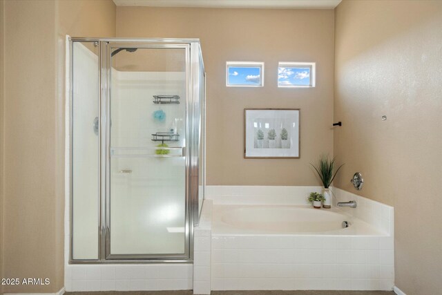 bathroom featuring a shower stall and a garden tub