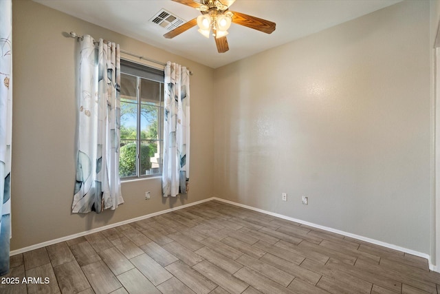 unfurnished room featuring visible vents, ceiling fan, wood finished floors, and baseboards