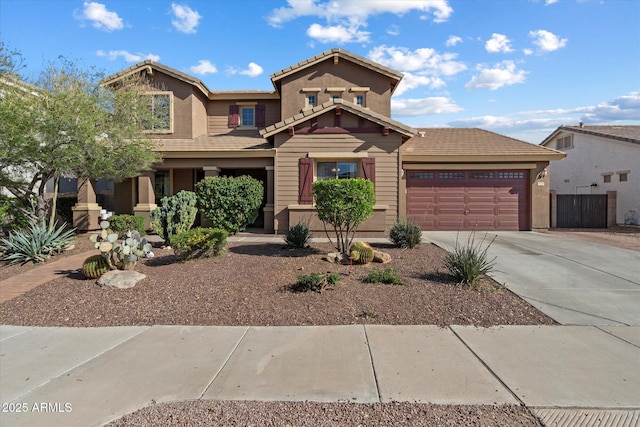 view of front of property featuring concrete driveway, stucco siding, a tiled roof, and an attached garage