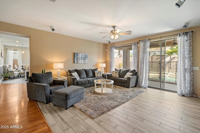 living room featuring light wood-style flooring and a ceiling fan