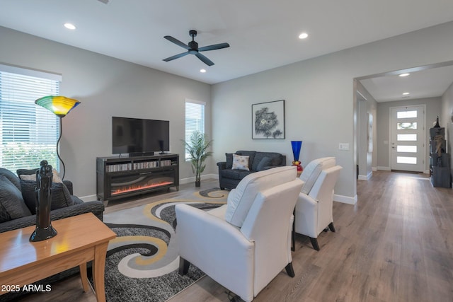 living room featuring ceiling fan, a healthy amount of sunlight, and wood-type flooring