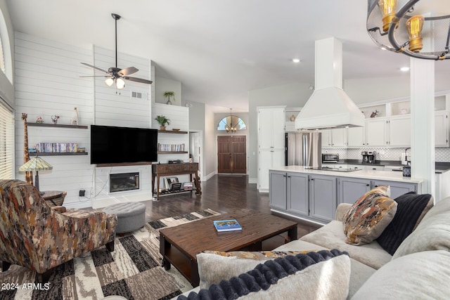 living room with ceiling fan, lofted ceiling, and dark hardwood / wood-style floors