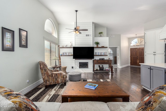 living room featuring dark hardwood / wood-style flooring, a fireplace, high vaulted ceiling, and ceiling fan