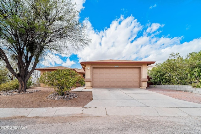 view of front of property featuring stucco siding, an attached garage, and driveway