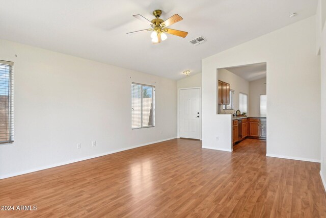 empty room featuring lofted ceiling, hardwood / wood-style flooring, and ceiling fan