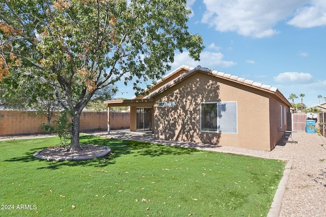 back of property featuring a patio and a yard