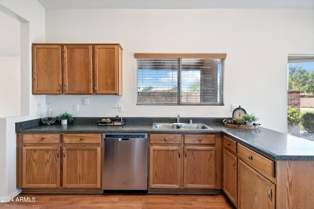 kitchen featuring sink, kitchen peninsula, dishwasher, and light wood-type flooring