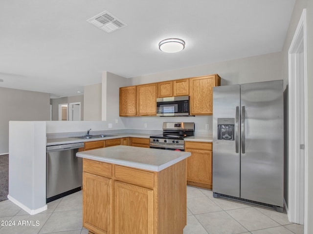 kitchen with stainless steel appliances, a center island, light tile patterned floors, and sink