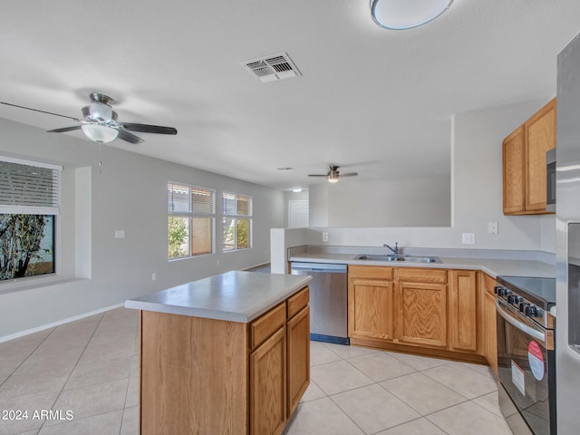 kitchen featuring ceiling fan, sink, light tile patterned floors, a kitchen island, and stainless steel appliances