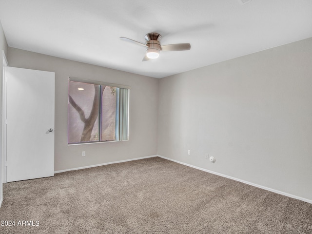 carpeted spare room featuring ceiling fan